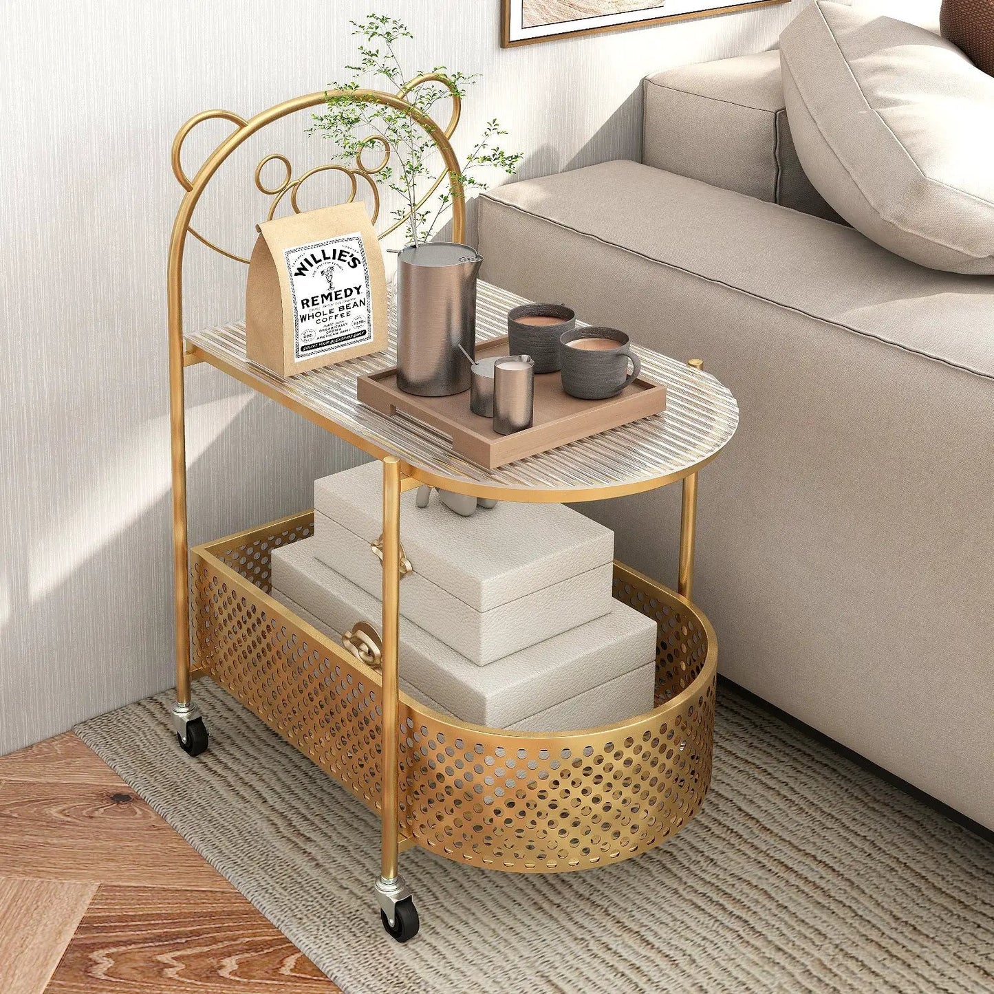 Gold metal rolling bar cart with perforated basket and wheels, holding coffee bag, plant, mugs on Tampa Home & Garden Store