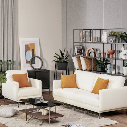 Modern sofa with metal legs and white upholstery, paired with an armchair and orange cushions on Tampa Home & Garden Store