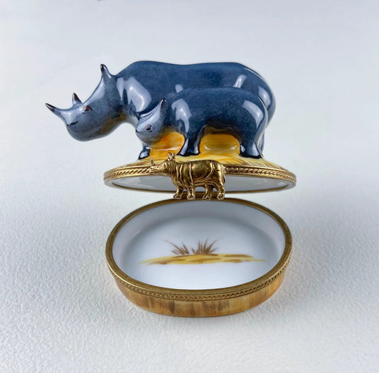 Mom and baby rhino Limoges figurine atop blue porcelain box with gold trim on Tampa Home & Garden Store