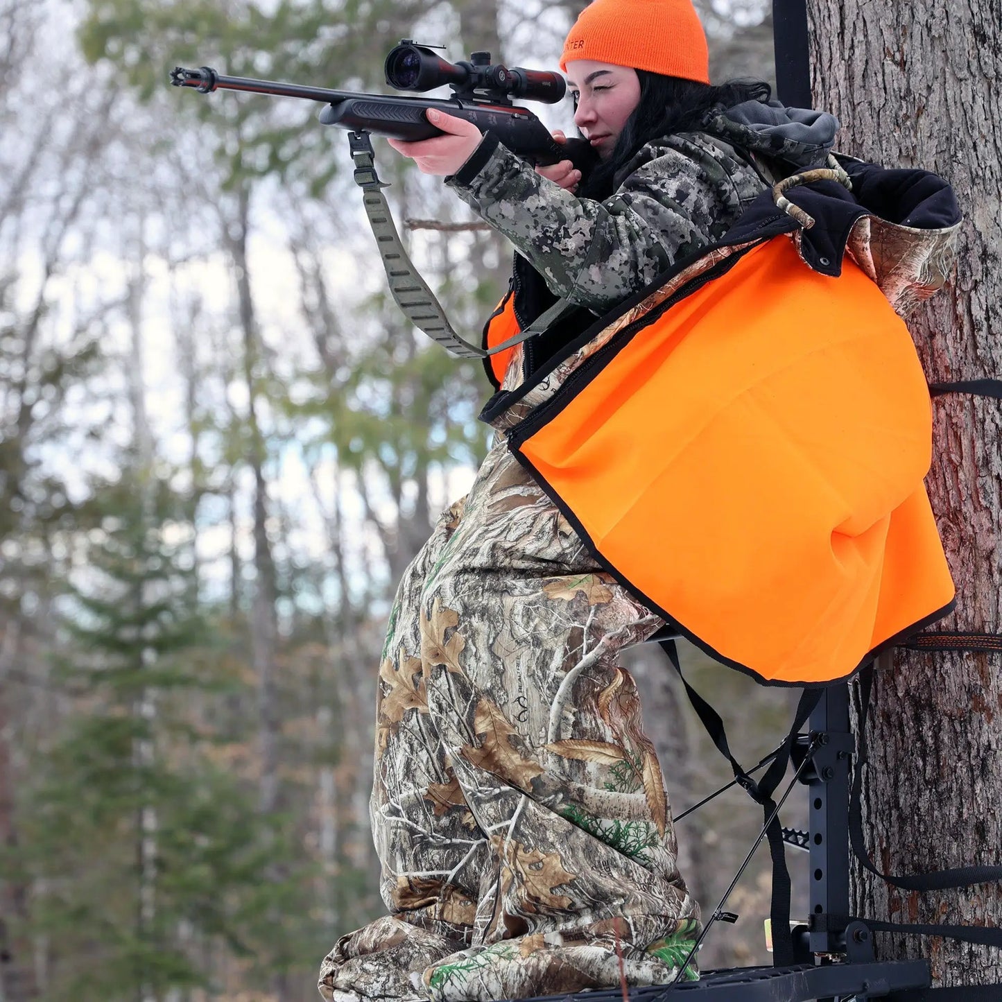 Heater Body Suit Xtreme Overlay outer layer worn by hunter aiming rifle in camo gear on Tampa Home & Garden Store