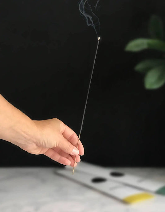Nirvana Incense stick for calm and positive spaces held in hand against a dark background on Tampa Home & Garden Store