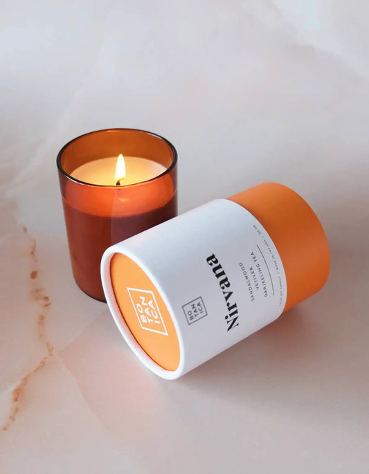 Nirvana Medium Candle Sandalwood Vetiver in orange glass jar with white label 7.5oz on Tampa Home & Garden Store