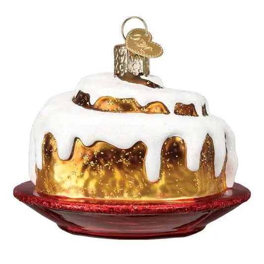 Old World Christmas Cinnamon Roll Ornament with white icing and gold glaze on a red plate on Tampa Home & Garden Store