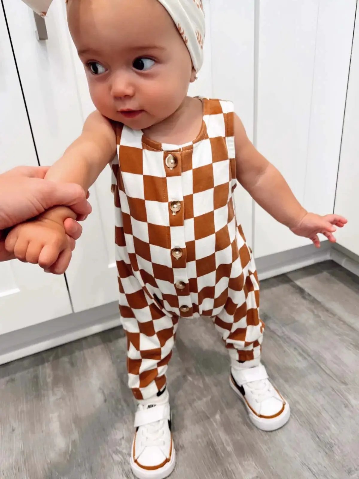 Organic checkerboard baby jumpsuit in brown and white, sleeveless with front buttons on Tampa Home & Garden Store