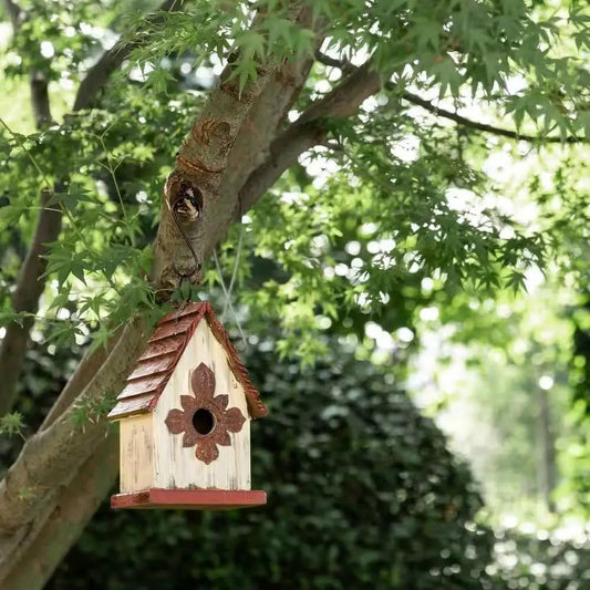 Outdoor A-Frame wooden bird house with terracotta roof, white body, hanging from a tree on Tampa Home & Garden Store