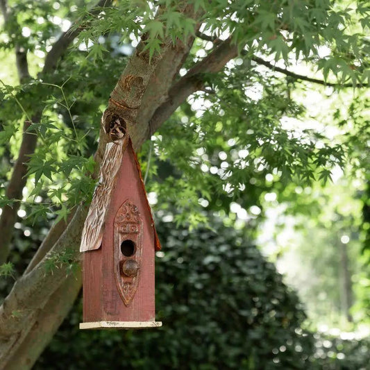 Outdoor Rustic Brown Wood and Iron Bird House by HomePacific hanging from a tree branch on Tampa Home & Garden Store