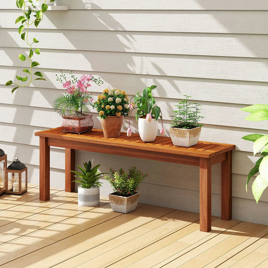 Outdoor wood bench for two backless patio seating in natural finish with potted plants on Tampa Home & Garden Store