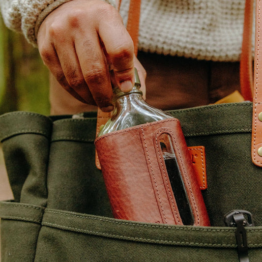 Will Leather Goods glass flask with brown full-grain leather sleeve, 375ml, held by hand on Tampa Home & Garden Store