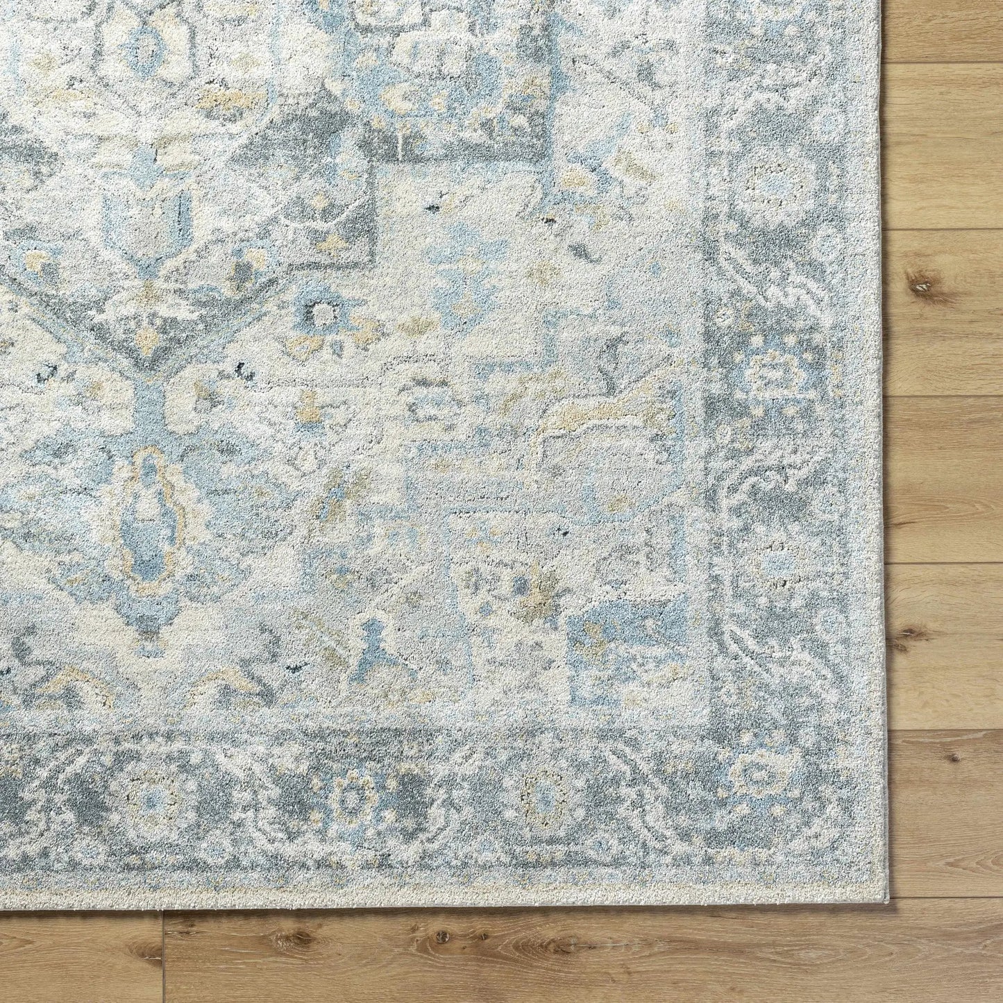 Akshay Light Gray Thick Luxe Area Rug with blue-gray beige distressed pattern on wood floor on Tampa Home & Garden Store