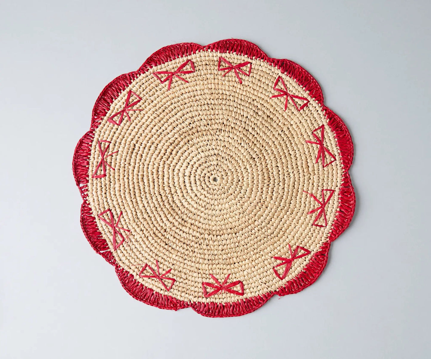 Payton James handwoven raffia palm placemat with red bow-stitch border, round natural beige on Tampa Home & Garden Store