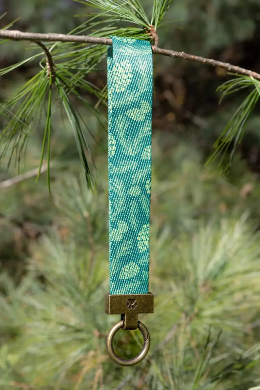 Pine Cone Pup Wristlet Keychain teal patterned ribbon with brass ring on pine branch on Tampa Home & Garden Store