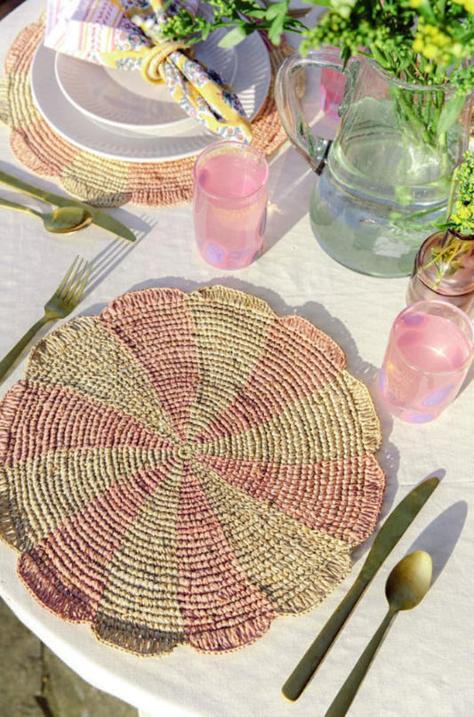 Pinwheel pink raffia crochet round placemat on a sunlit table with pink glassware and cutlery on Tampa Home & Garden Store