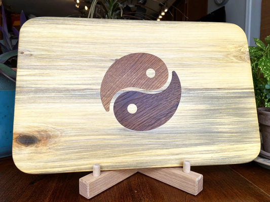 Poplar charcuterie board with dark walnut yin-yang inlay on light wood surface on a wooden stand on Tampa Home & Garden Store