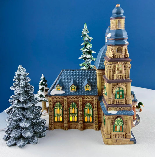 Porcelain Christmas Village St Mary's Cathedral with snow-dusted evergreens and glowing windows on Tampa Home & Garden Store