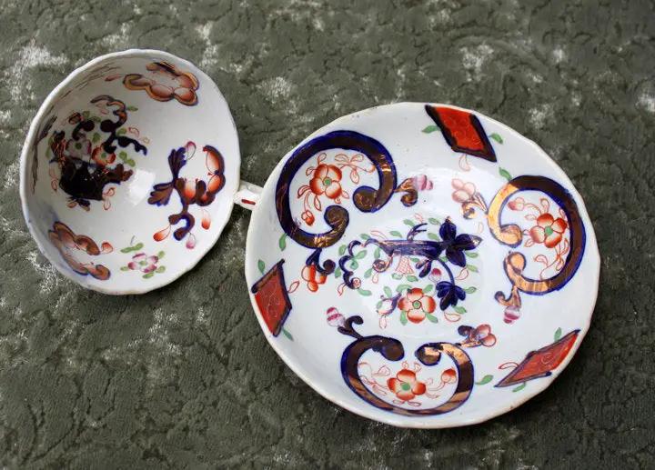 Porcelain teacup and saucer set hand-painted in Japan with colorful floral scrolls on Tampa Home & Garden Store