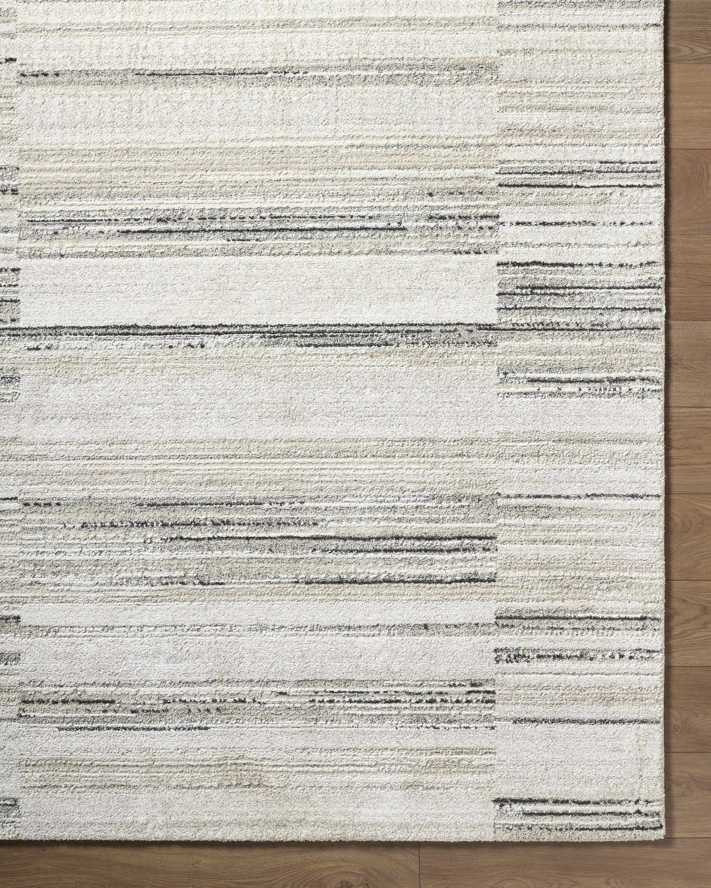 Rumer Luxe Rug in white and cream with a subtle striped pattern on wood floor on Tampa Home & Garden Store