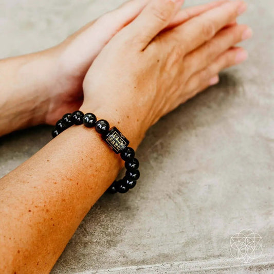 Rainbow Obsidian Protection Bracelet featuring black beads and etched charm on wrist on Tampa Home & Garden Store
