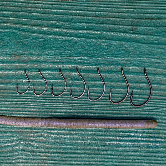 Reaction Tackle Drop Shot Hooks Pack of 50, curved metal fishing hooks resting on a teal surface on Tampa Home & Garden Store