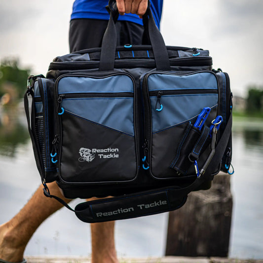Reaction Tackle saltwater tackle bags with blue accents and multiple pockets, logo visible on Tampa Home & Garden Store
