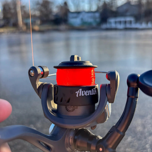 Reaction Tackle ICE monofilament fishing line spool on an Aventik reel with bright orange line on Tampa Home & Garden Store