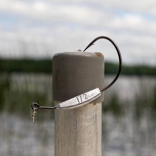 Reaction Tackle lead weighted swimbait hook on a gray post with a metal tag, outdoor background on Tampa Home & Garden Store