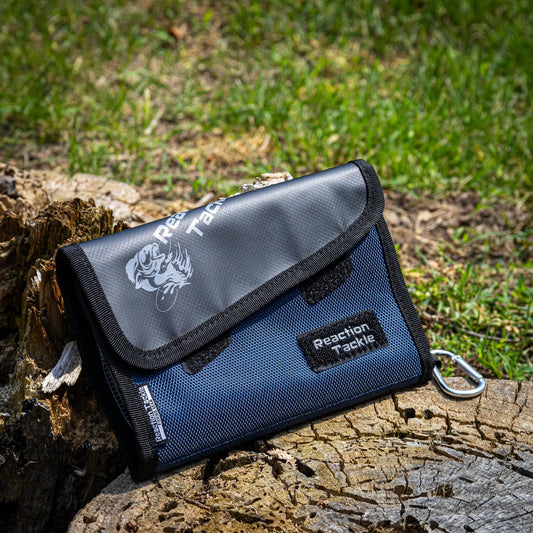 Reaction Tackle Small Bait Binder Compact fishing tackle bag in blue with logo on a log on Tampa Home & Garden Store