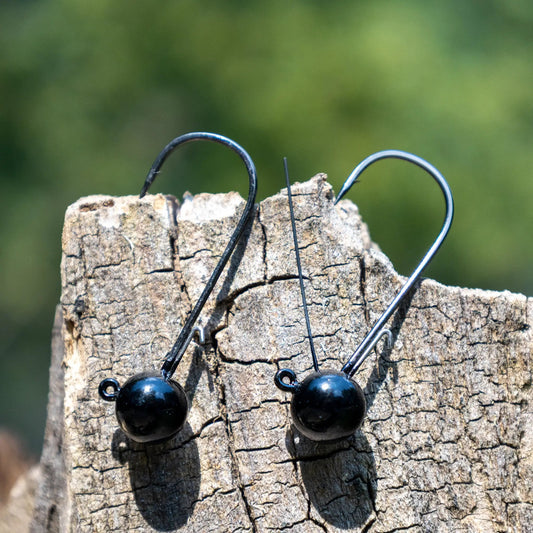 Reaction Tackle tungsten ball jig heads for bass, black spherical heads with hooks on wood set on Tampa Home & Garden Store