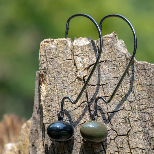 Three tungsten football swing jig heads 3-pack in black and olive with curved hooks on wood, on Tampa Home & Garden Store