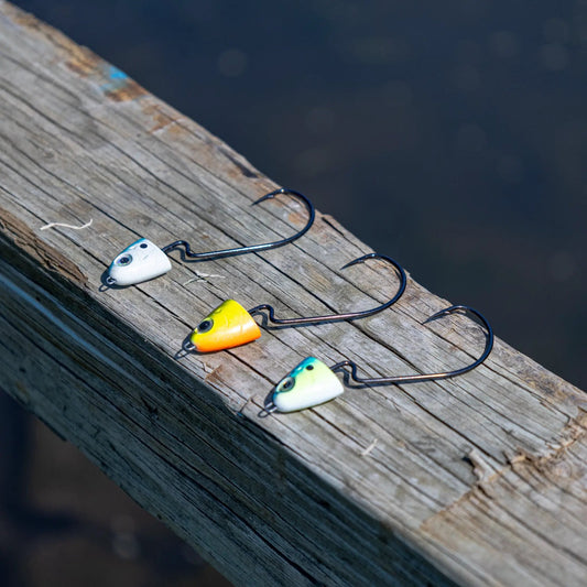 Reaction Tackle tungsten swing swimbait jig heads several colorful heads on weathered dock on Tampa Home & Garden Store