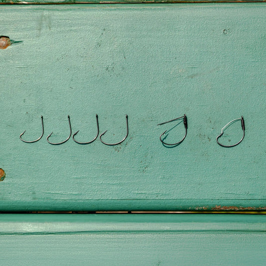 Reaction Tackle wide gap wacky hooks, 25 pack, row of curved fishing hooks on turquoise wood on Tampa Home & Garden Store