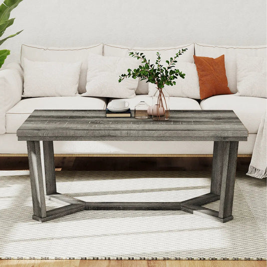 Rectangular coffee table with a cross-shaped rubber wood base and weathered gray top on Tampa Home & Garden Store
