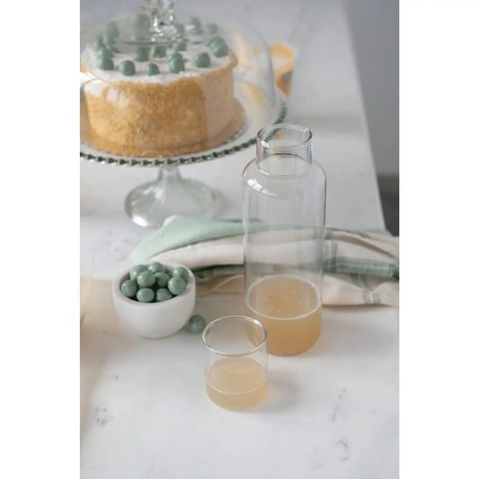 Recycled glass decanter and two clear hand-blown drinking glasses set on Tampa Home & Garden Store