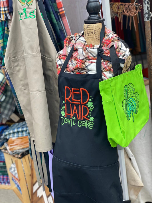 Red Hair Don't Care embroidered canvas apron by Thistle & Stitch in navy with red lettering on Tampa Home & Garden Store
