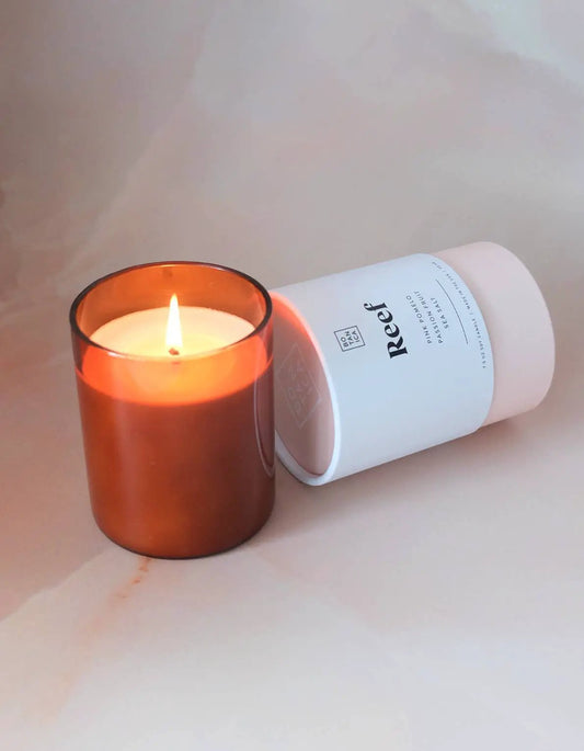 Reef Medium Candle sea salt and fruit scent in amber glass with white label sleeve on Tampa Home & Garden Store