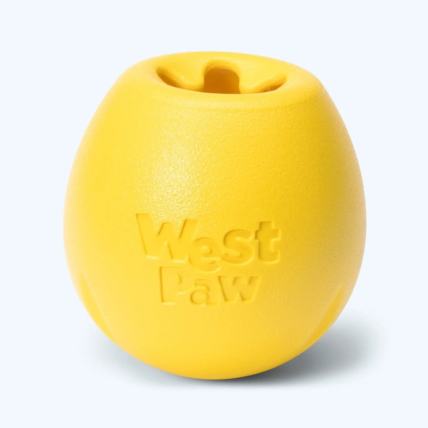 Rumbl dog toy by West Paw, yellow treat-dispensing puzzle ball with hollow center on Tampa Home & Garden Store