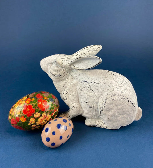 Rustic Bunny Figurine with cracked white paint and 3 Easter eggs on blue backdrop on Tampa Home & Garden Store