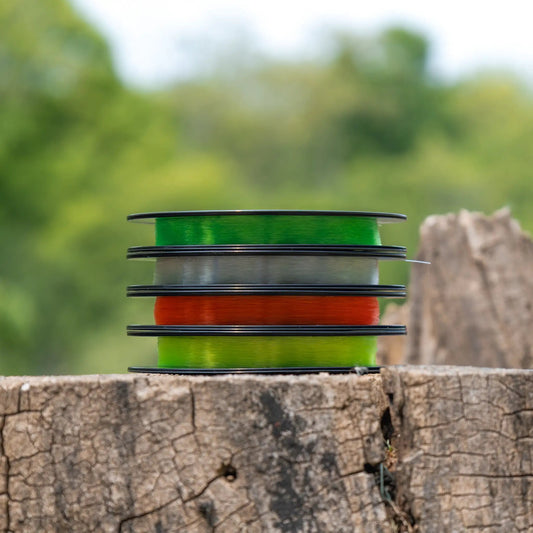 Monofilament nylon fishing line spools, green and orange, three stacked reels on Tampa Home & Garden Store