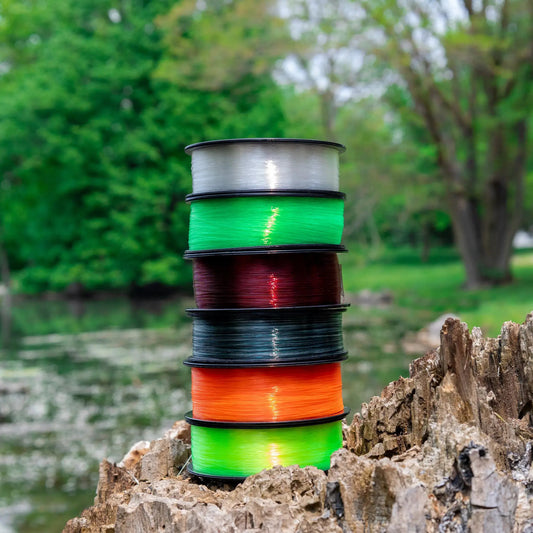 Monofilament fishing line by Reaction Tackle spools in white green orange stacked outdoors on Tampa Home & Garden Store