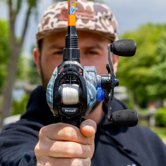 Reaction Tackle StreamX baitcasting reel with orange rod, 7.5:1 gear ratio close-up view on Tampa Home & Garden Store