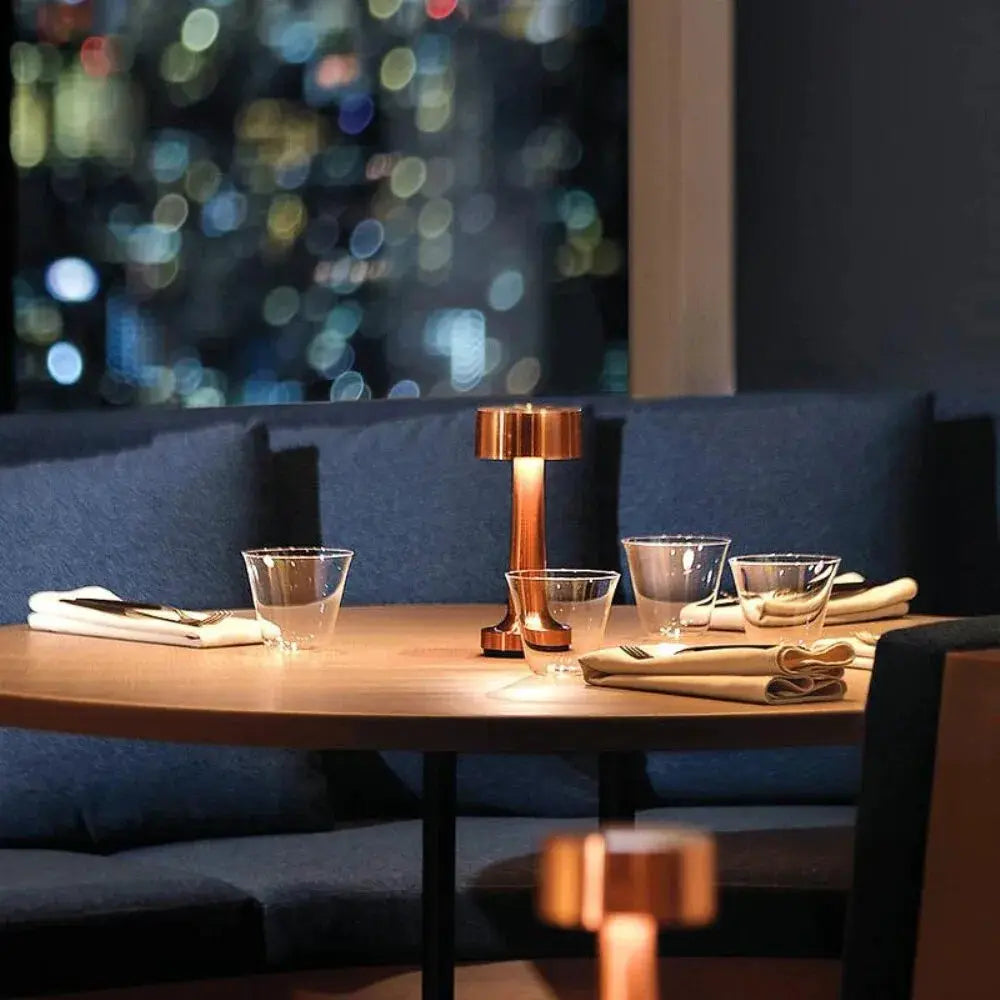 Rechargeable LED touch table lamps in copper finish, two Moktan Sabai units on a dining table on Tampa Home & Garden Store