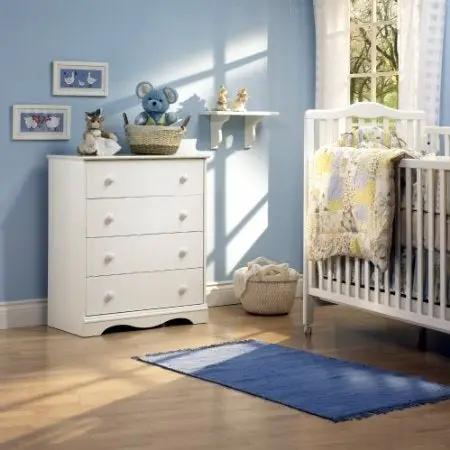 White 4-drawer dresser with wooden knobs in a blue nursery beside a crib on Tampa Home & Garden Store