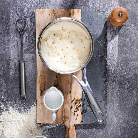 Castel’Pro saucepan set with Cristel spoon on board; cream sauce in pan with peppercorns on Tampa Home & Garden Store