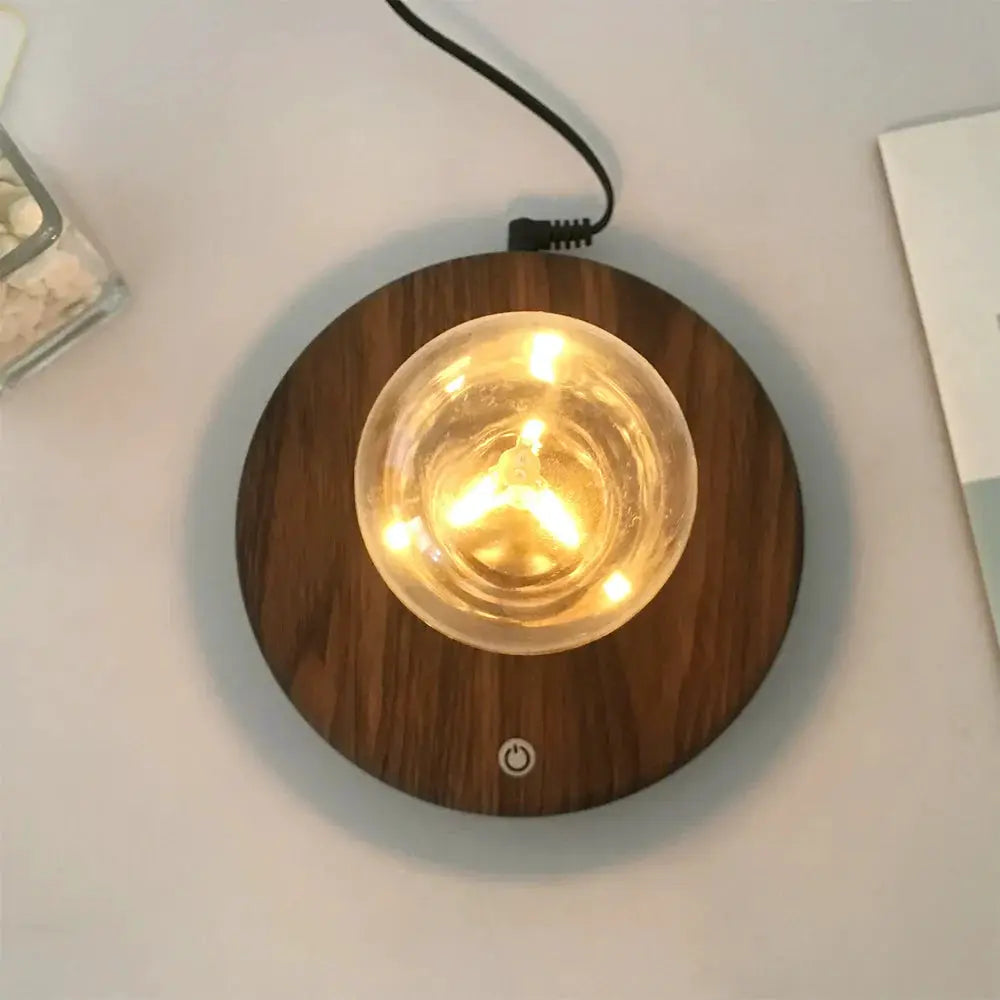 Moktan Sabai magnetic levitation floating LED desk lamp on round wooden base with warm glow on Tampa Home & Garden Store