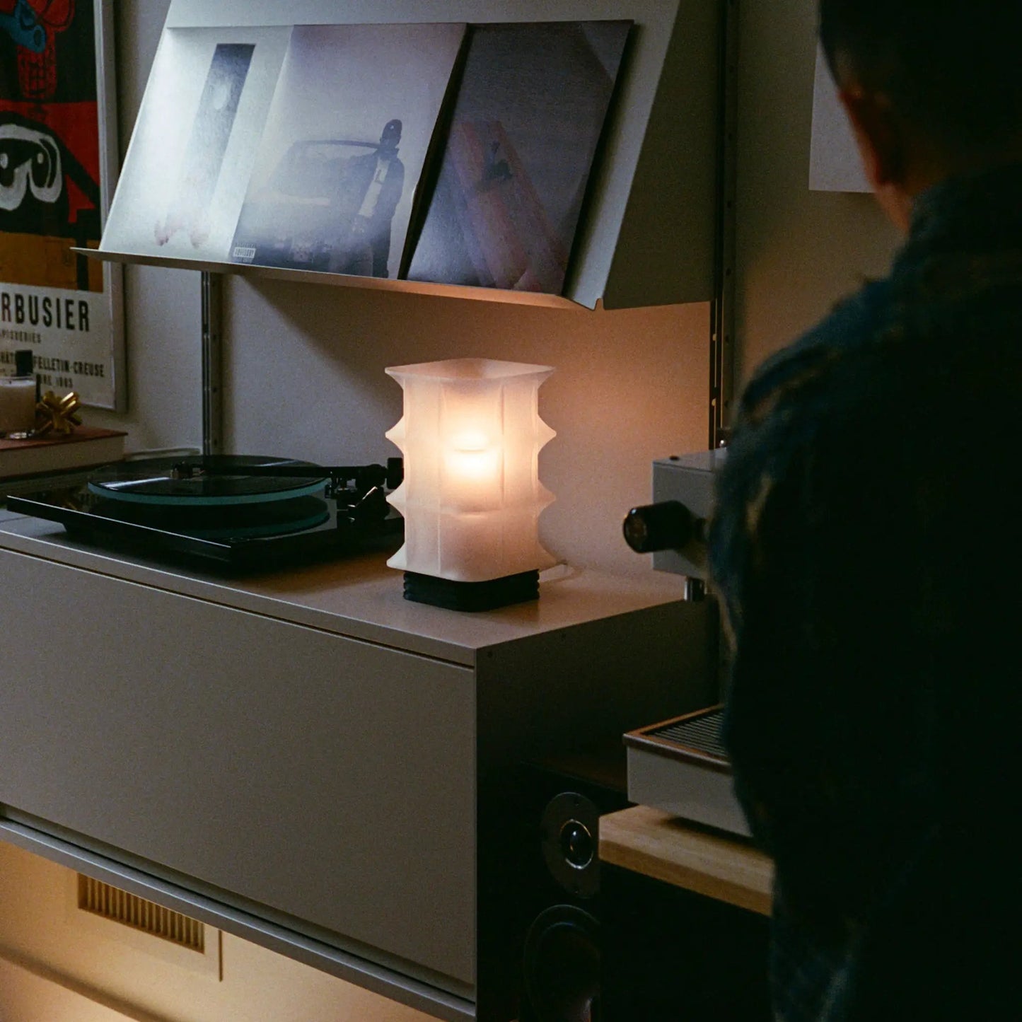 Scaffold Lamp with white paper lantern shade on black stacked base, on shelf near a turntable on Tampa Home & Garden Store