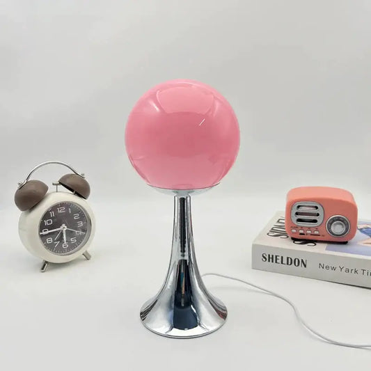 Glass pink globe lamp on chrome pedestal beside vintage clock and pink radio on desk on Tampa Home & Garden Store
