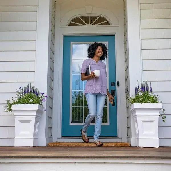 Set of 2 24-inch white self-watering planter boxes by HomePacific on a front porch with purple flowers on Tampa Home & Garden Store