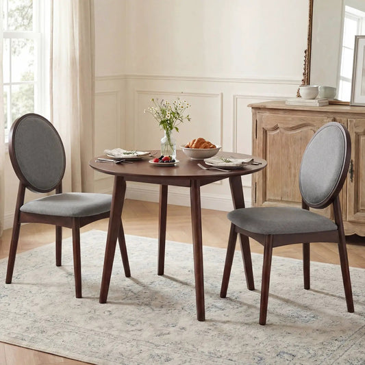 Two upholstered linen kitchen side chairs with padded gray round backs and dark wood legs on Tampa Home & Garden Store