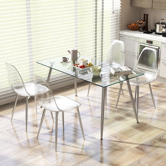 Set of four dining chairs with clear acrylic seats and silver legs around a glass table on Tampa Home & Garden Store
