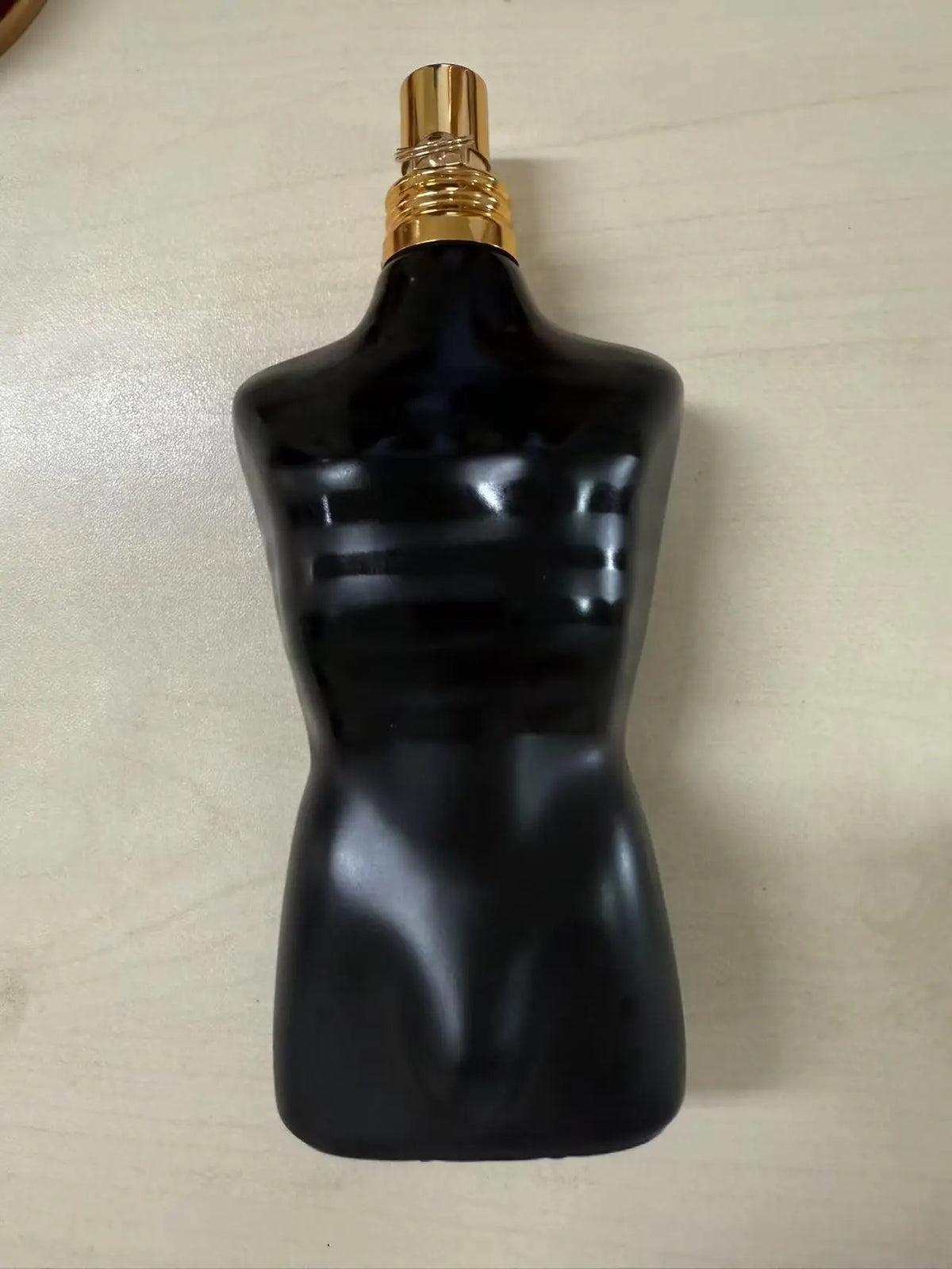 Jean Paul Gaultier Le Male Elixir perfume bottle, black torso with gold spray cap on Tampa Home & Garden Store