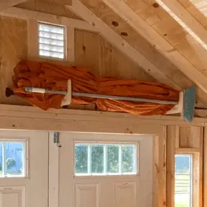 Shed Storage Organizer for Yard Tool Rack with orange tarp on a hanging rack inside a shed on Tampa Home & Garden Store